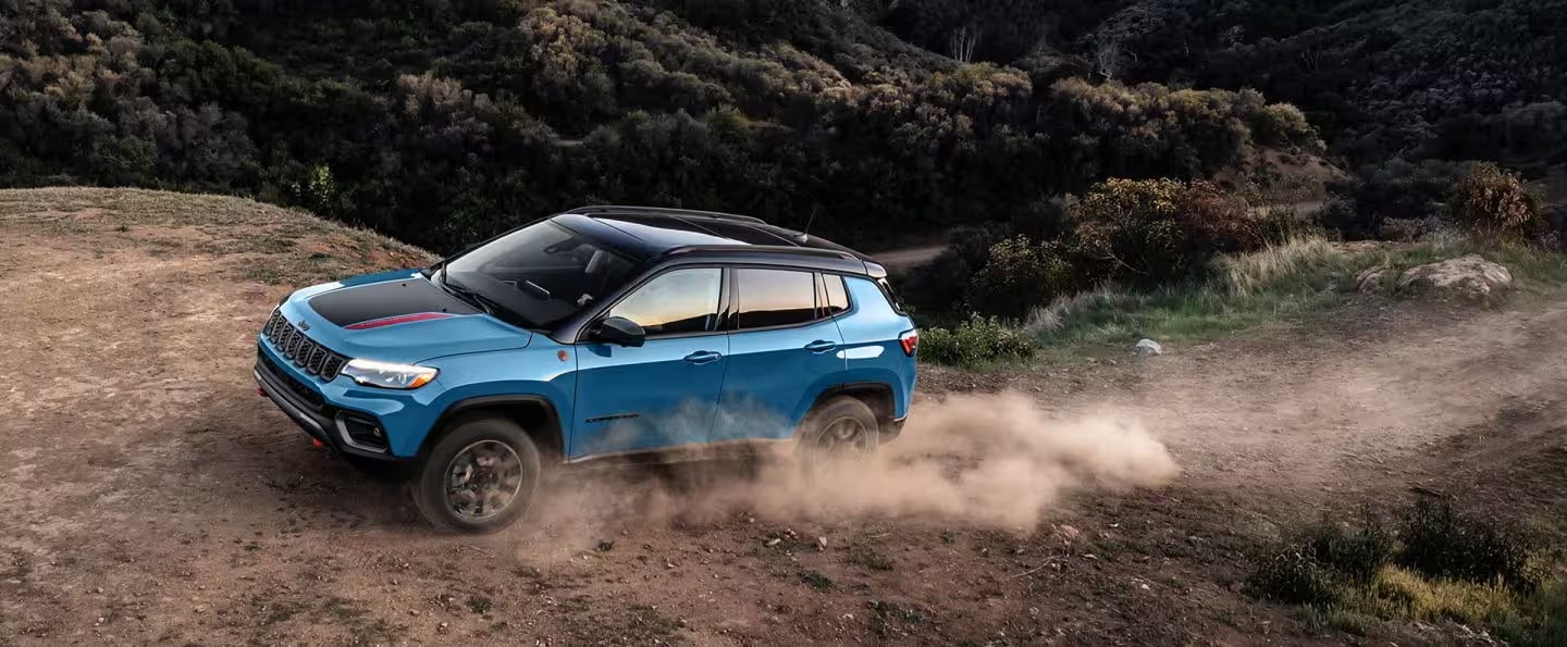 Blue 2025 Jeep Compass driving up a mountain